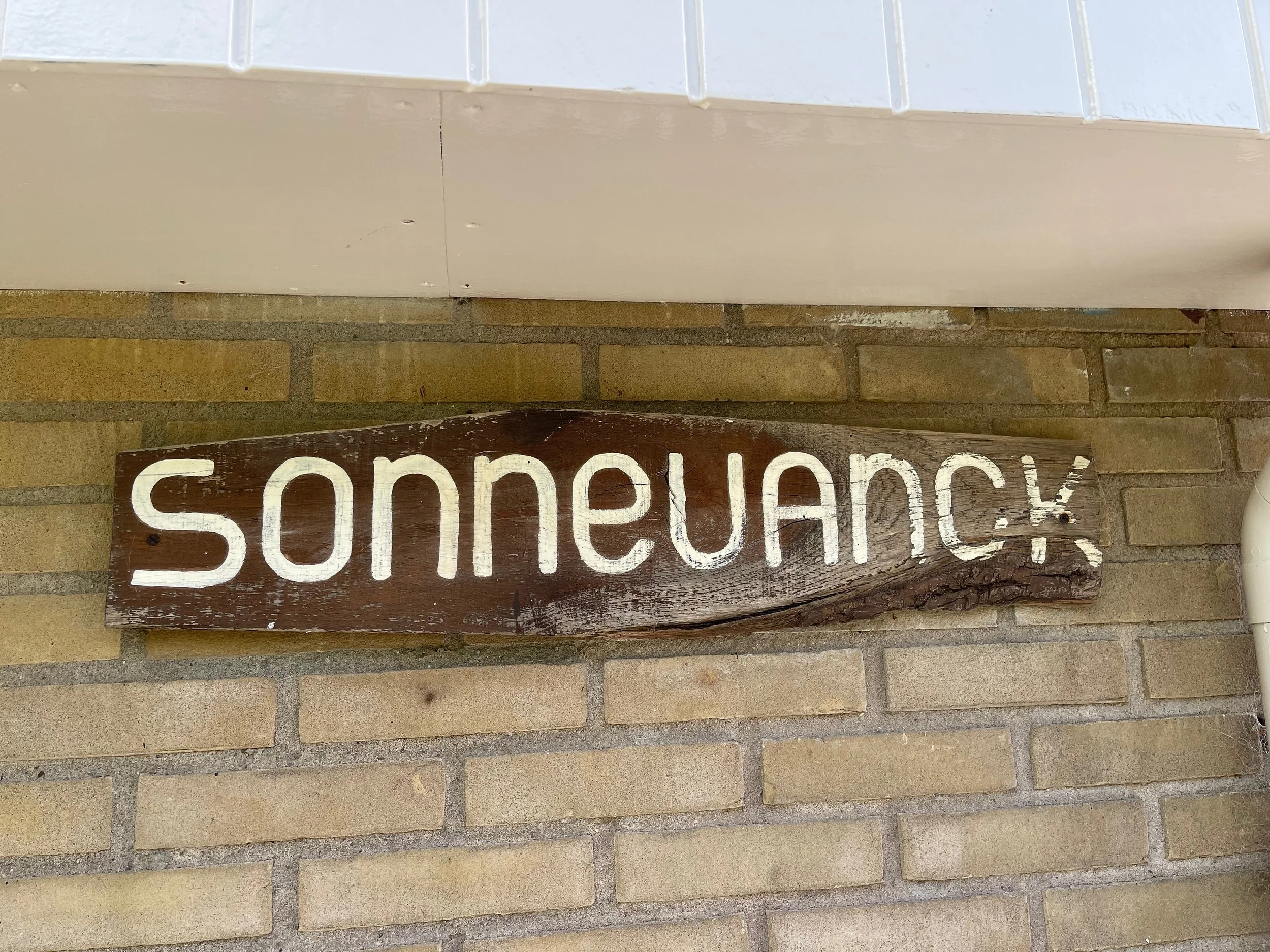 Houten naambord van Bungalow Sonnevanck aan de gevel in Ballum op Ameland