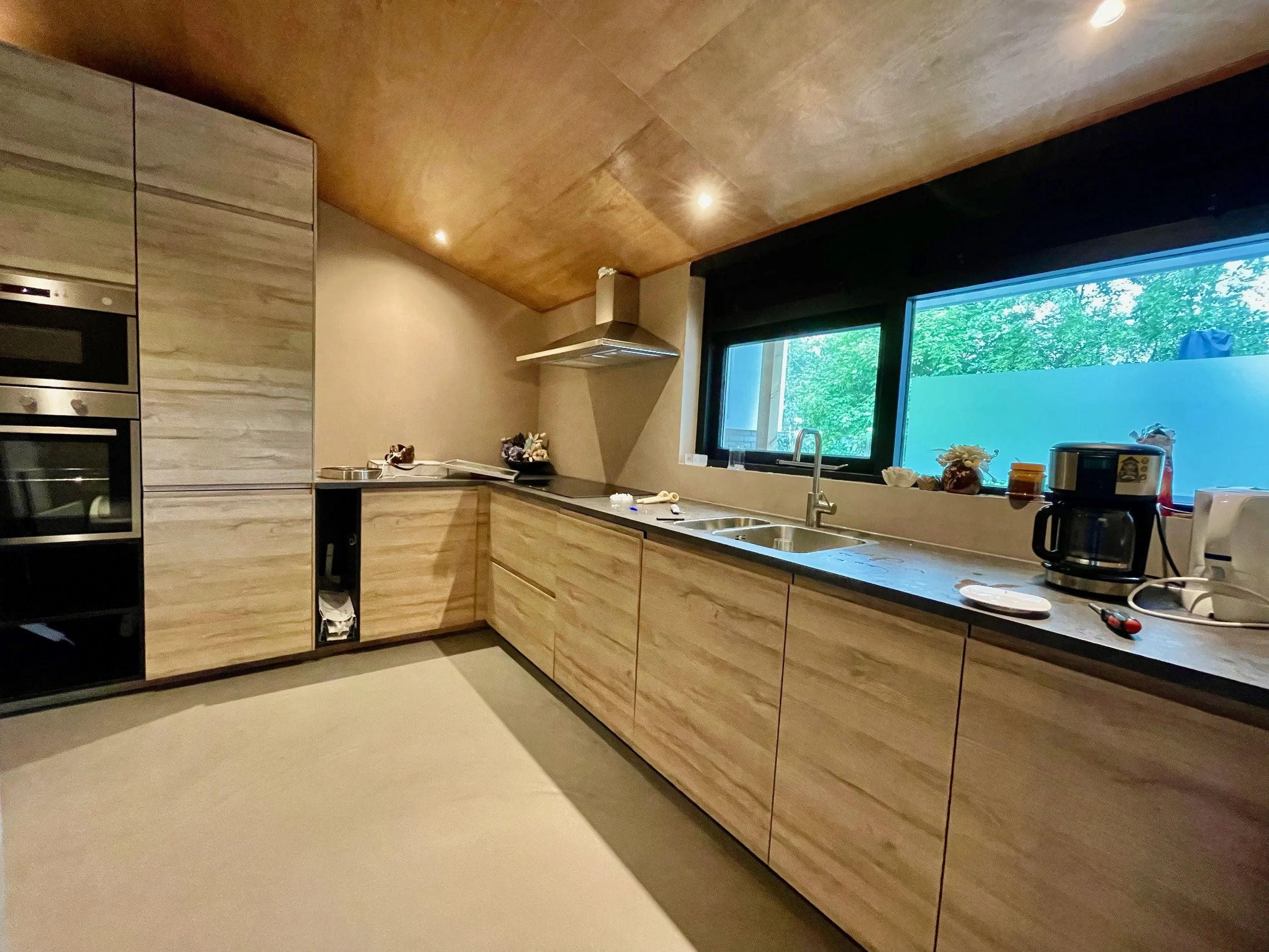 Keuken met houten kasten en uitzicht op het groen in Bungalow Luitekamp in Ballum op Ameland