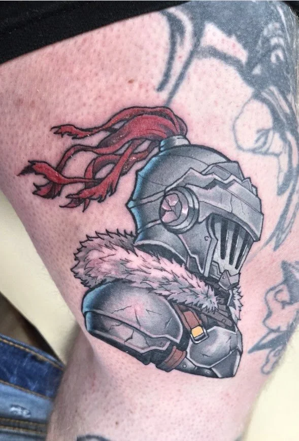 Tattoo of a medieval knight in armor with a helmet, fur collar, and red riddled headband. goblin slayer