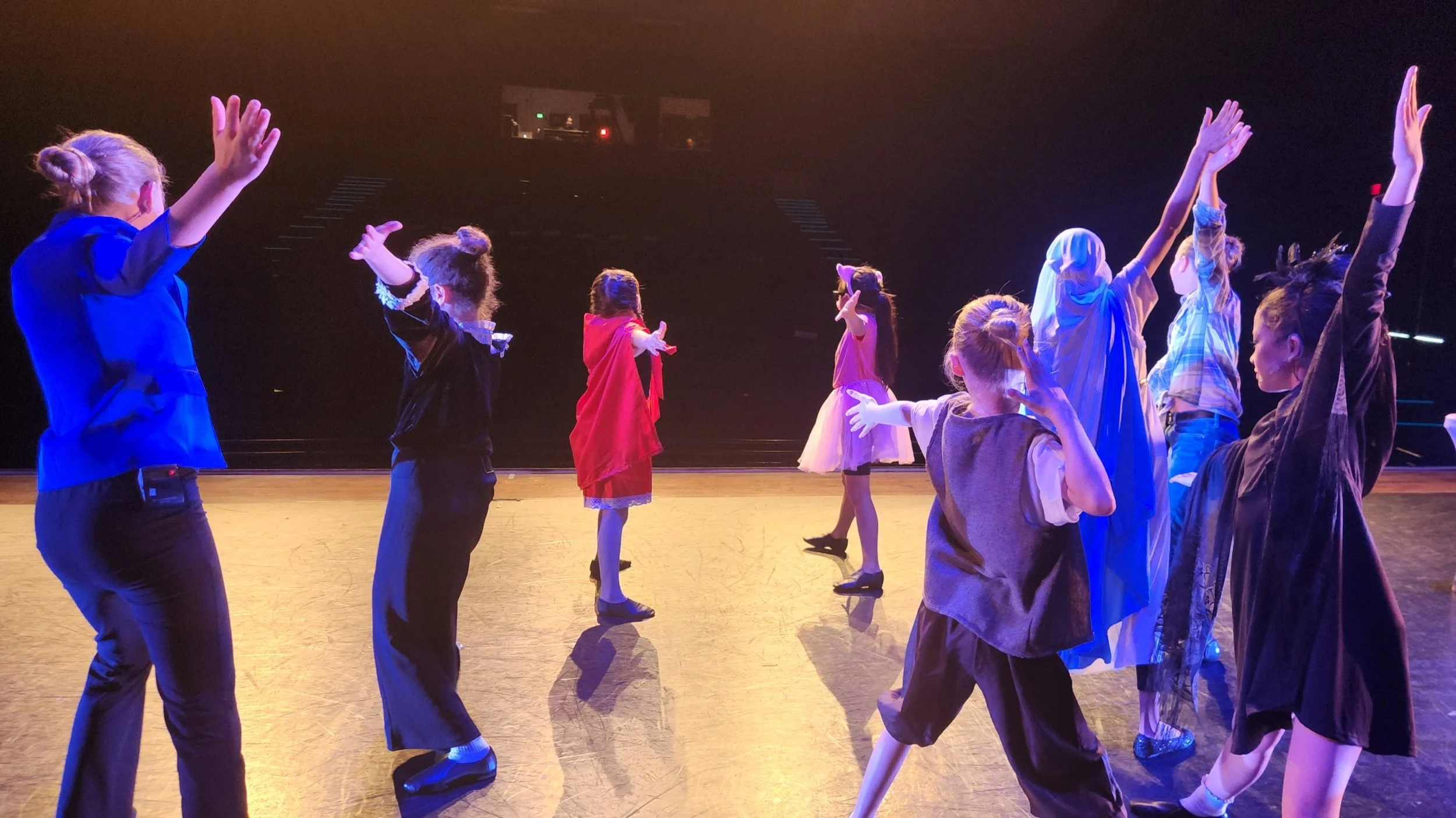 Children dressed in costumes performing on stage.
