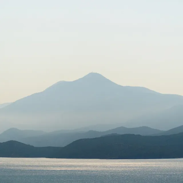 Paisaje de montañas y un cuerpo de agua, con una montaña importante en el fondo.