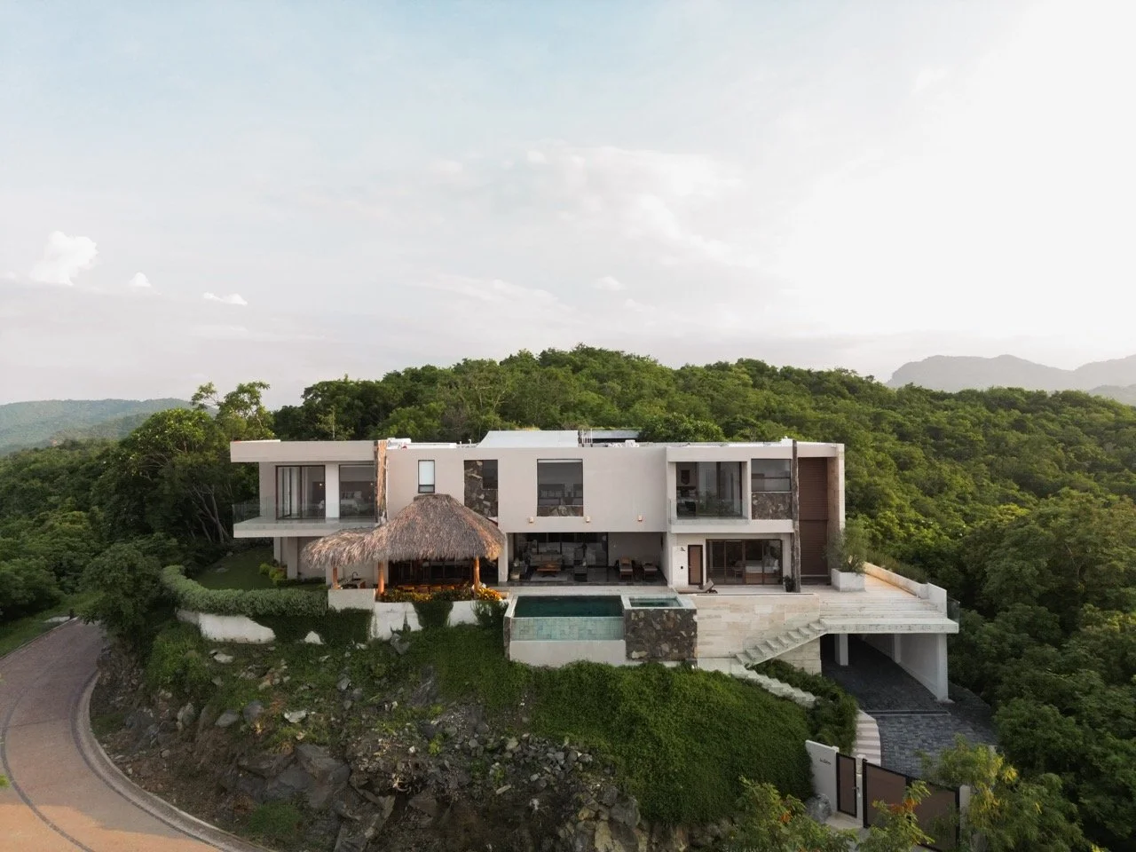 Casa moderna en una colina rodeada de naturaleza con piscina y terraza.