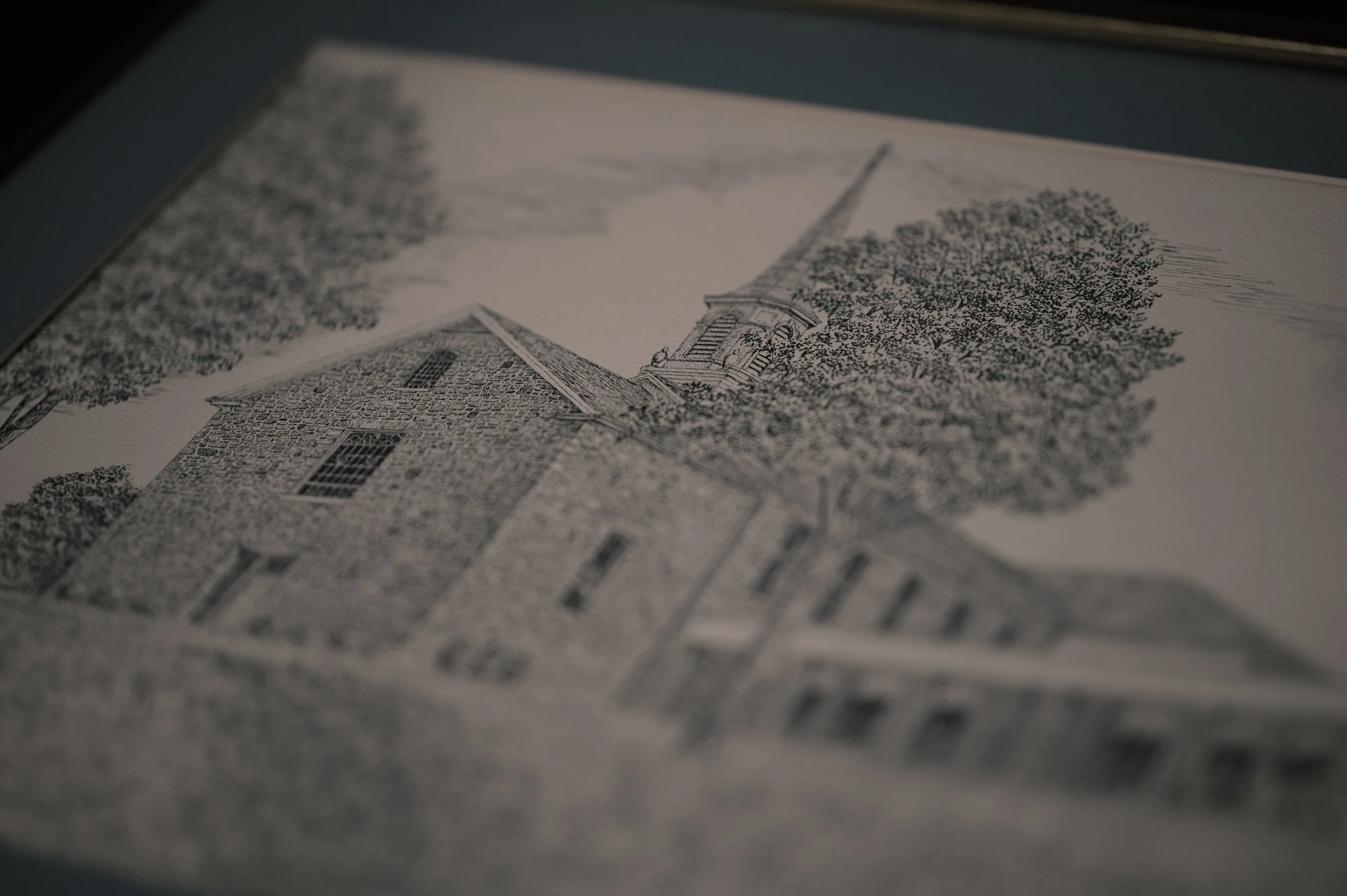 Close-up of a printed illustration of a church and trees, possibly on paper or a postcard.