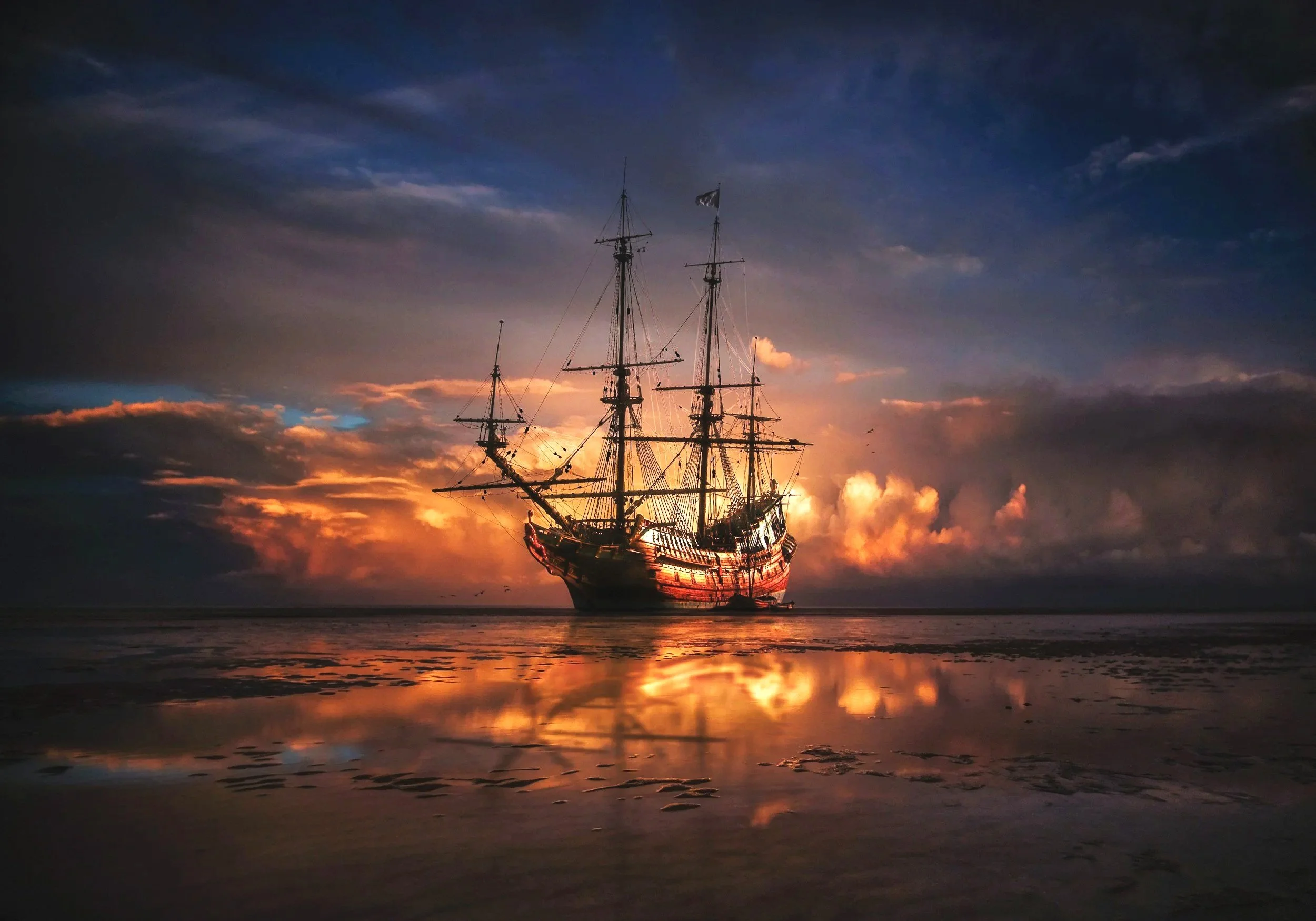 A ship sailing off into a sunset