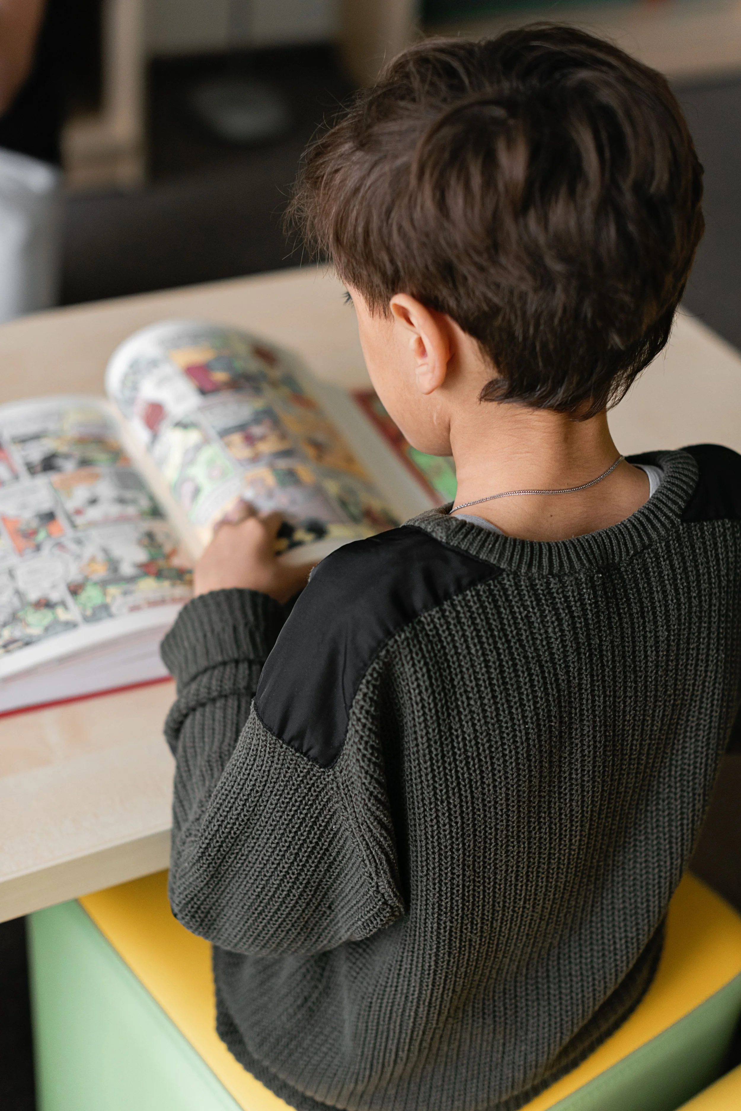 Elementary student practicing reading comprehension and literacy skills at a table.