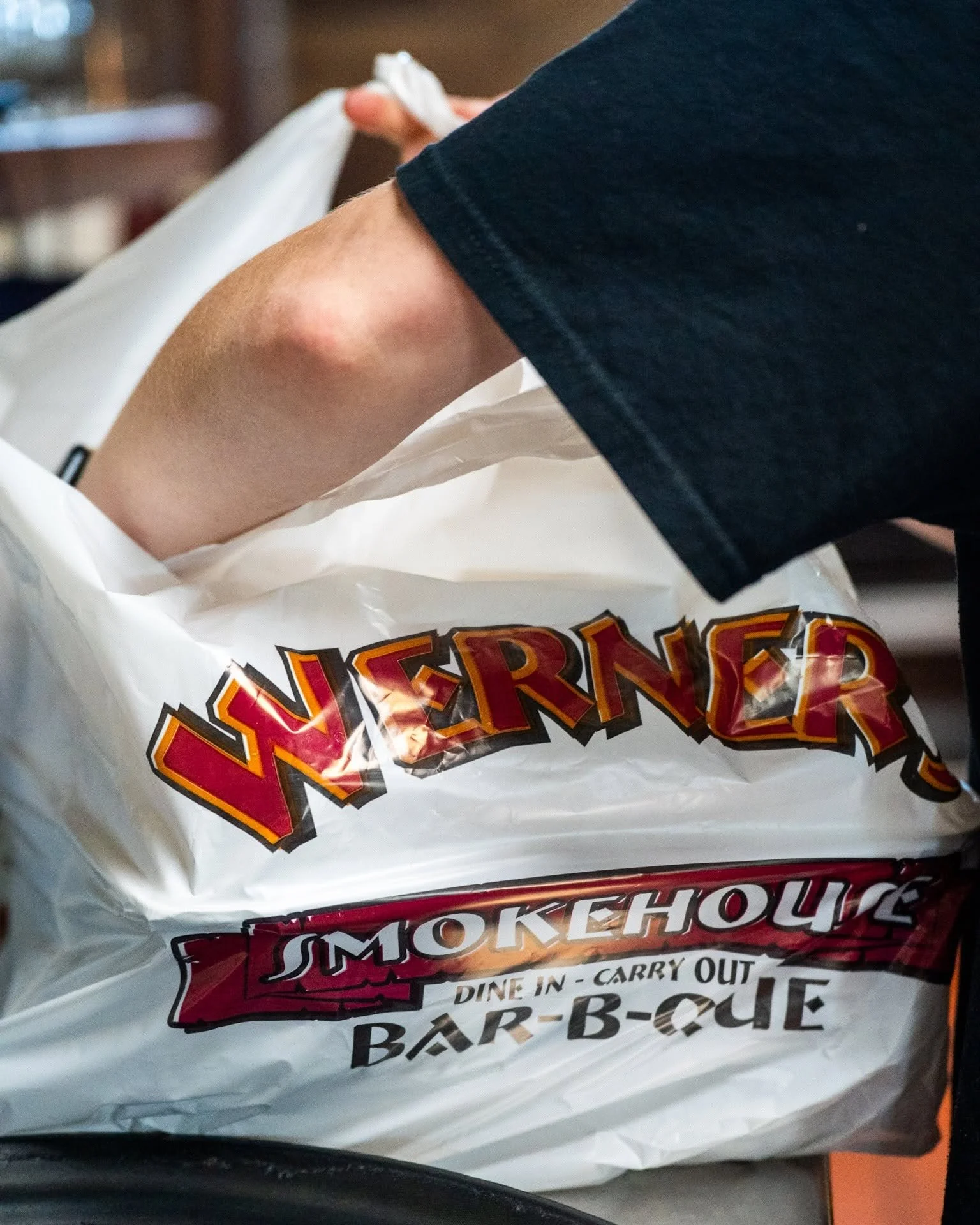 Barbecue takeout bag from Smokehouse with finished food inside.