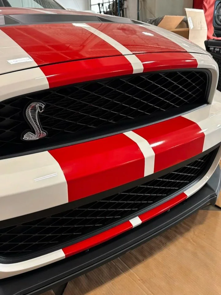 Precision is in the details.
Not every project is a full vehicle wrap.
For this Shelby GT500, we completed the installation of replacement factory-style stripe graphics on the front bumper and rocker panels as part of an insurance repair for Cam Clar