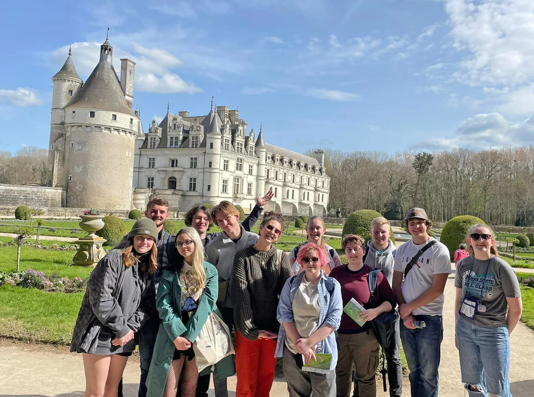 Columbia Falls High School students standing outdoors in front of a large historic castle with towers on a school-funded international trip.