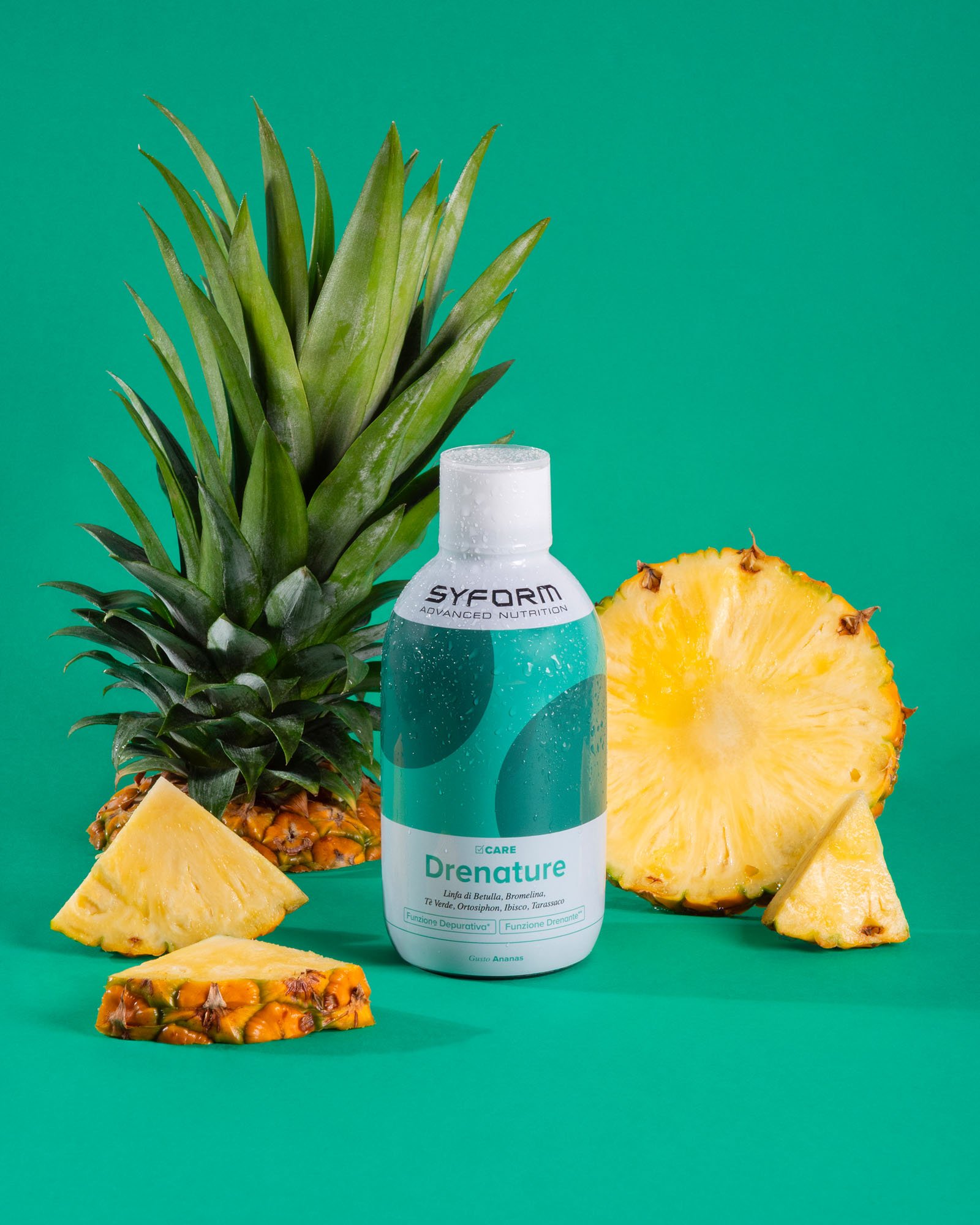 Una bottiglia di prodotto chiamato 'Drentuture' circondata da pezzi di ananas e un'insieme di foglie di ananas, su uno sfondo verde.