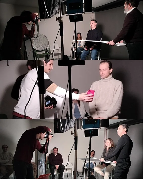 Set fotografico con persone che posano e scattano foto, attrezzature di luci e telecamere in uno studio.