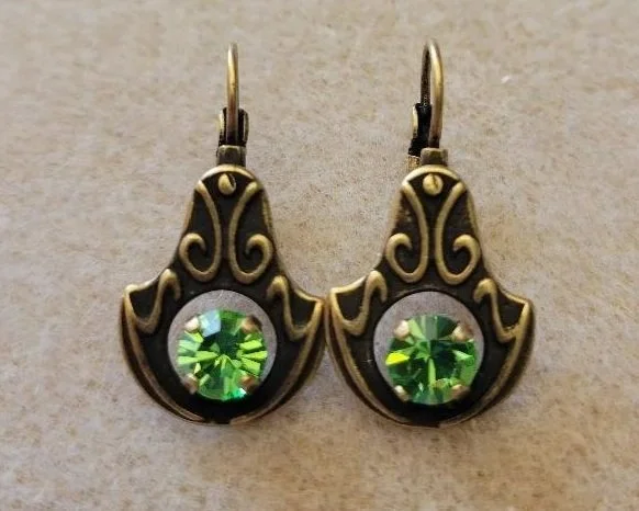Vintage-style earrings with gold filigree and green gemstone accents.