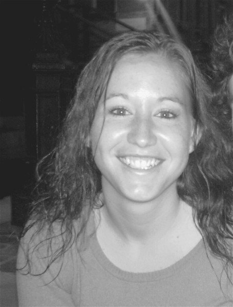A young woman smiling with curly hair, in a black and white photo. Brianna Rizzi artist