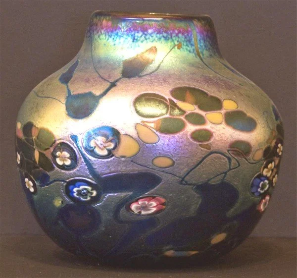 Colorful glass vase with floral and abstract patterns.