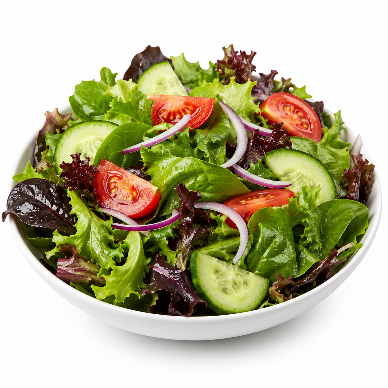 Fresh mixed green salad with cherry tomatoes, cucumber slices, and red onion in a white bowl.