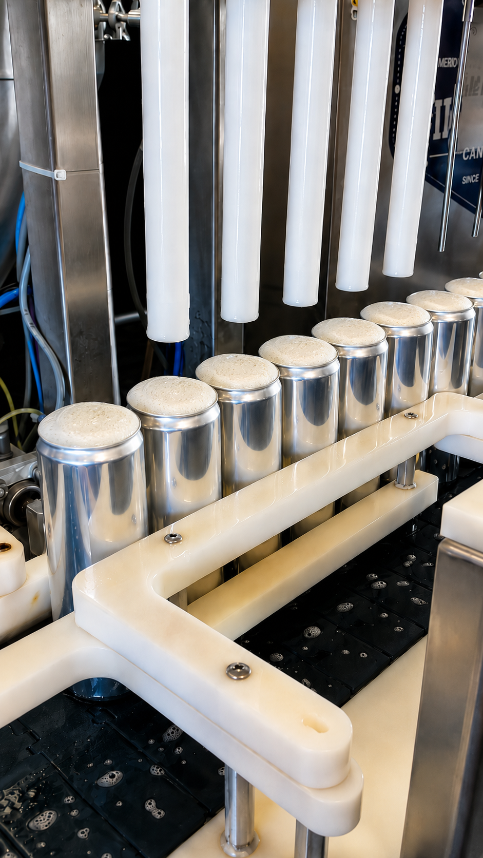 A machine filling cans with beer or soda, with foam overflowing at the top.