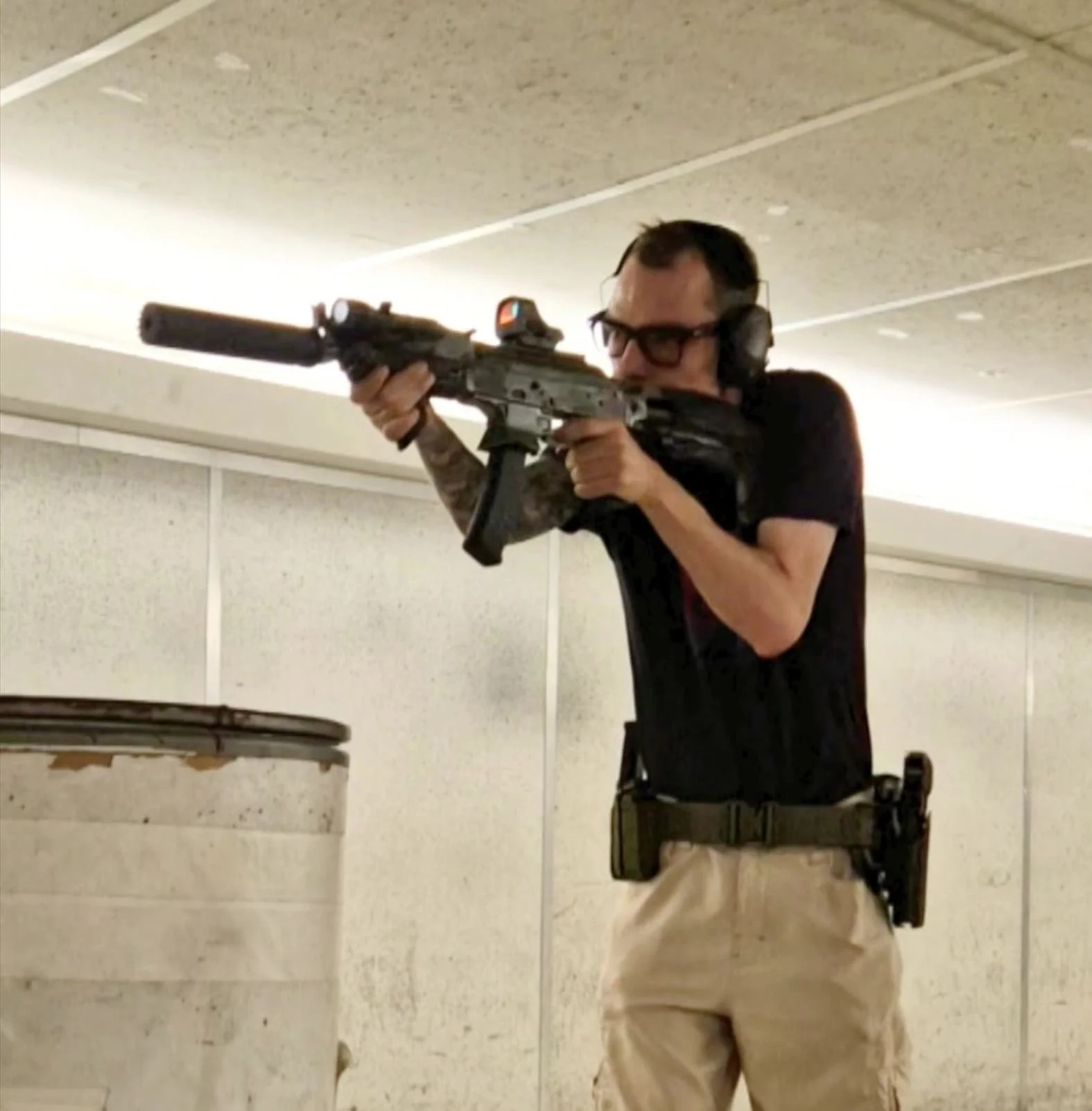 A man aiming a rifle at a shooting range.
