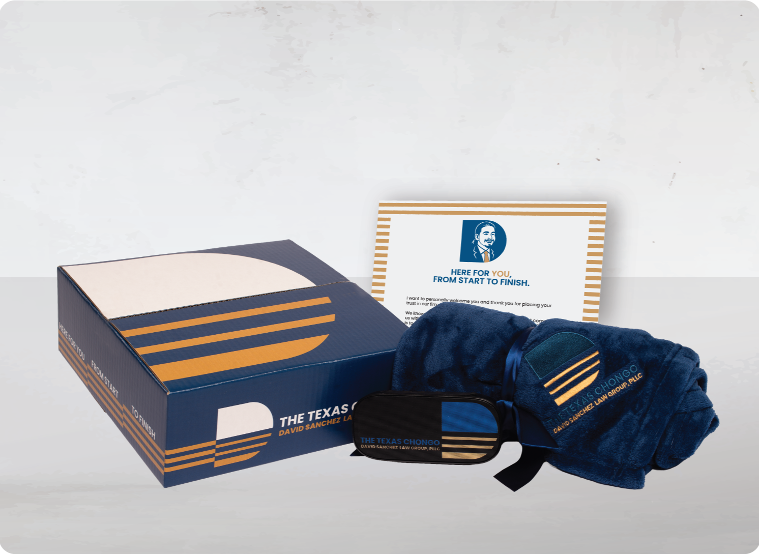 Box of promotional items for The Texas Chongo, including a reusable bag, blanket, eye mask, and a thank you note, all branded with the company's logo and colors.