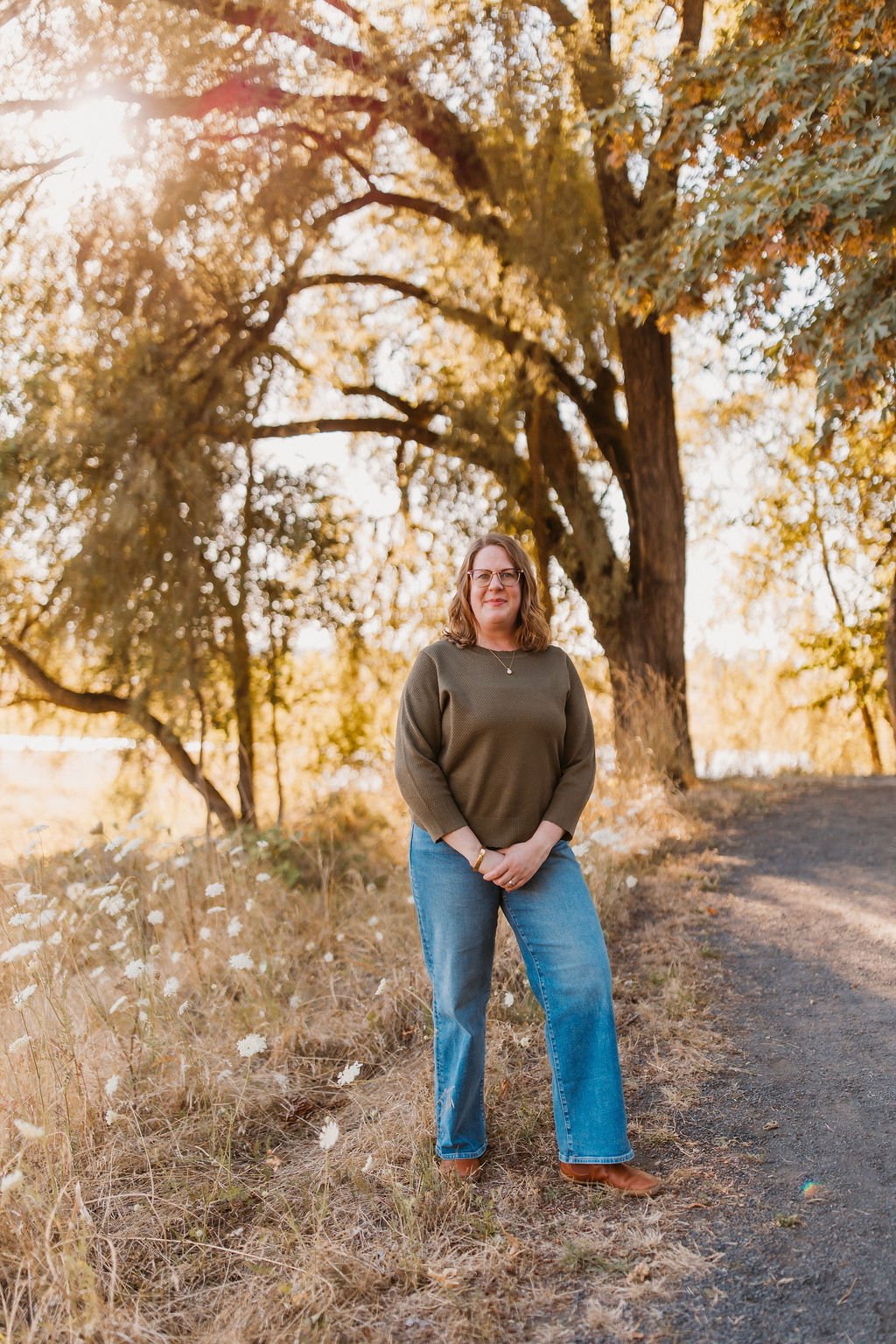 Ashley Sullivan standing outdoors among dry grasses, natural light