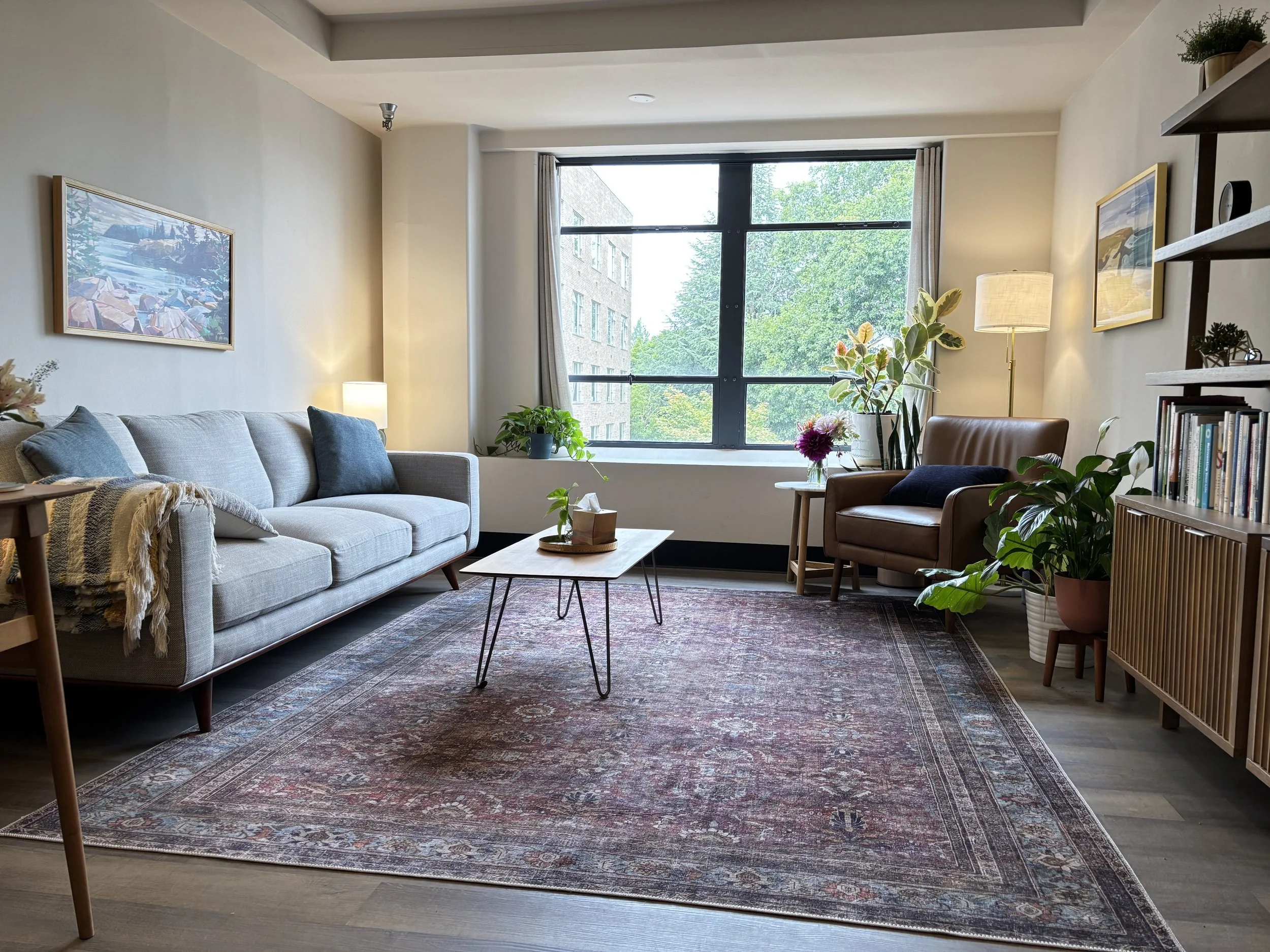 Warm, calming therapy office with couch, plants, and natural light near Mt. Tabor