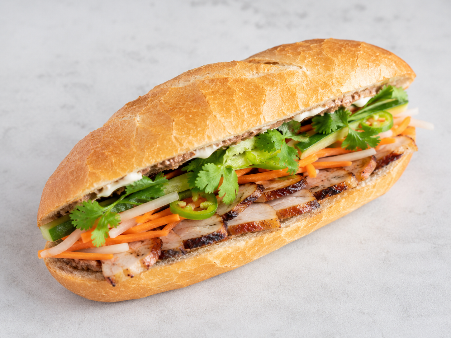 Sub sandwich with grilled chicken, fresh vegetables, and herbs in a baguette
