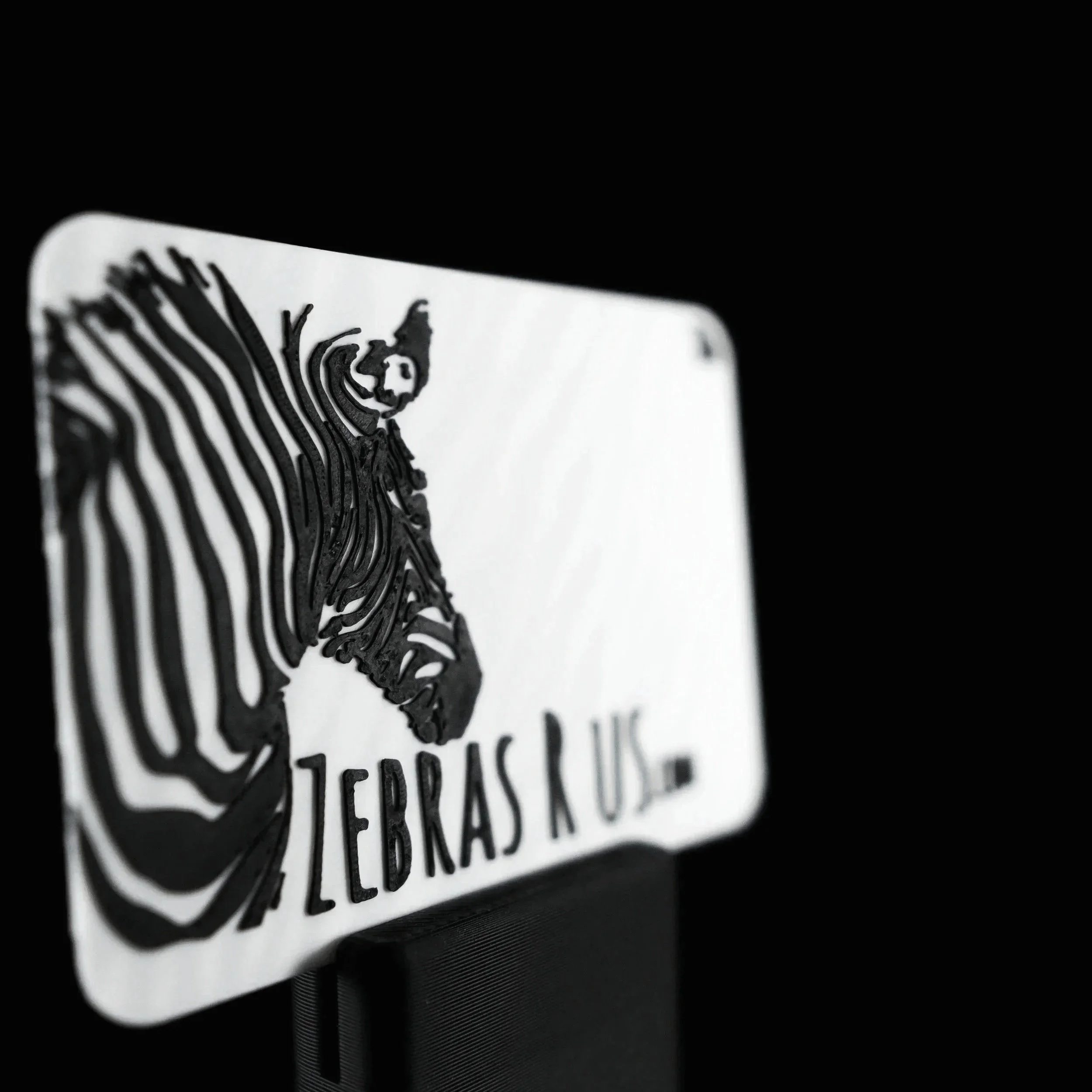 Close-up of a custom 3D printed NFC business card with black and white zebra design and text.