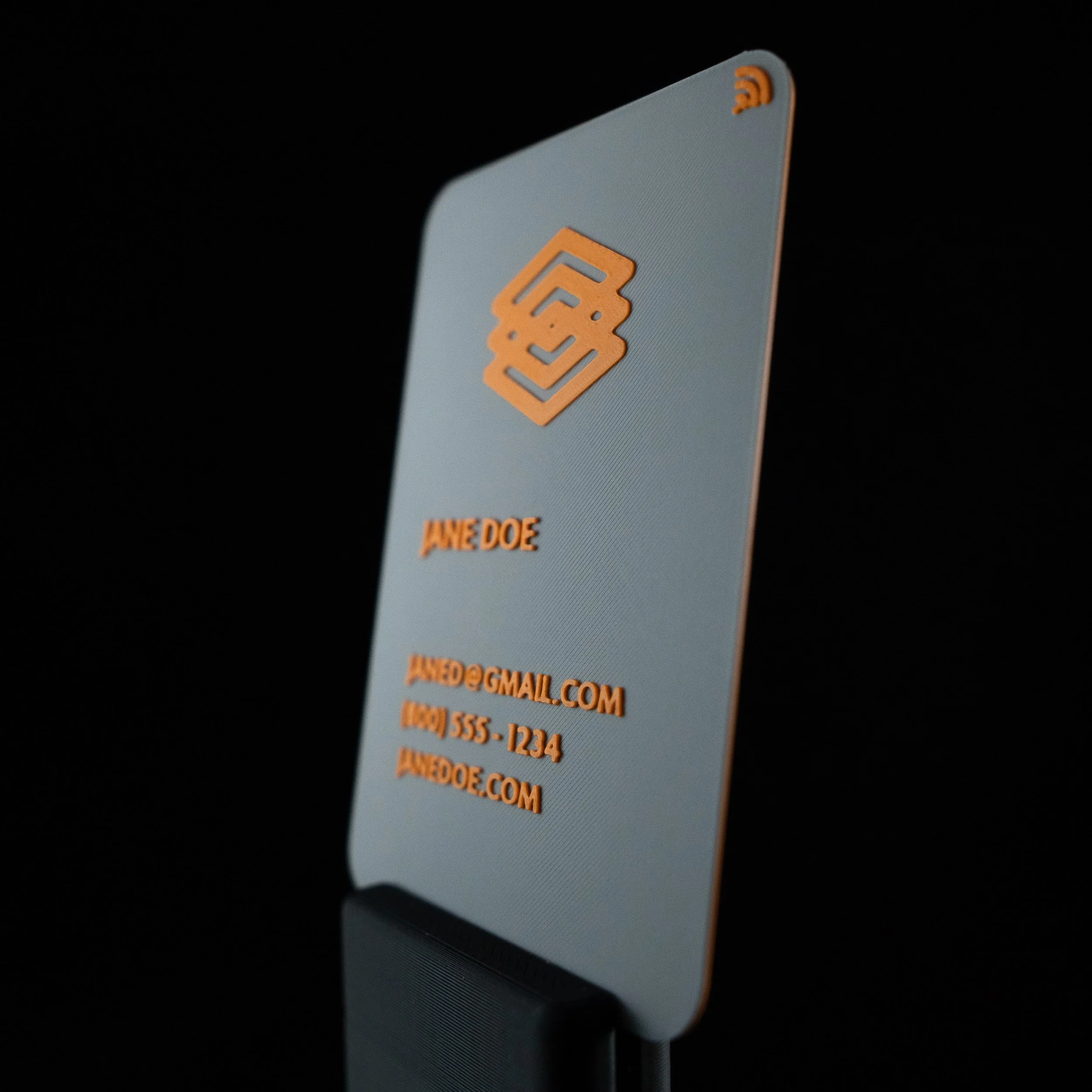 A 3D printed business card with an orange and grey color scheme. 