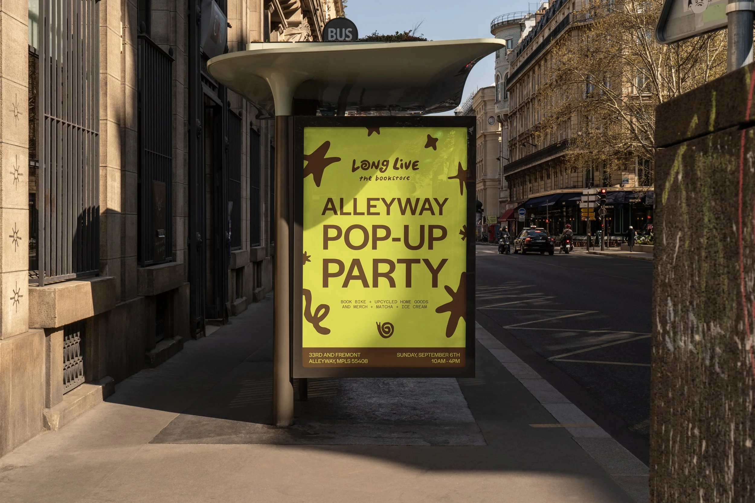 A mockup billboard on a city sidewalk advertises a Long Live The Bookstore pop-up party, with a yellow background, brown text, and decorative elements.