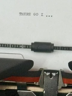Vintage typewriter with the words "THERE GO I..." typed on the page.