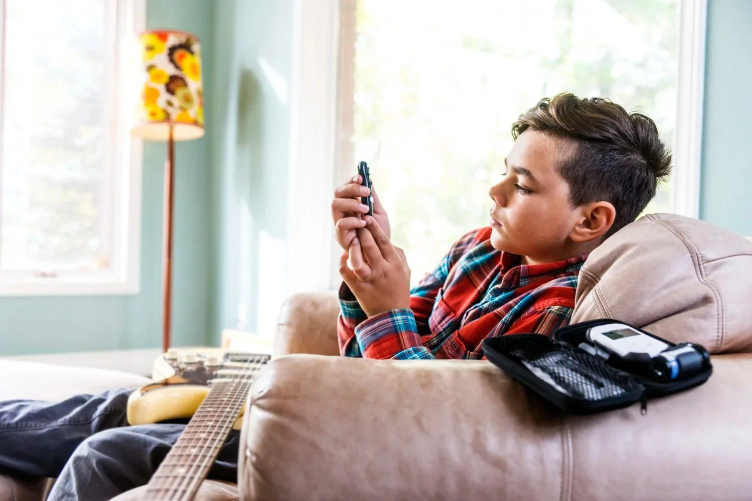 A boy checks his blood sugar at home
