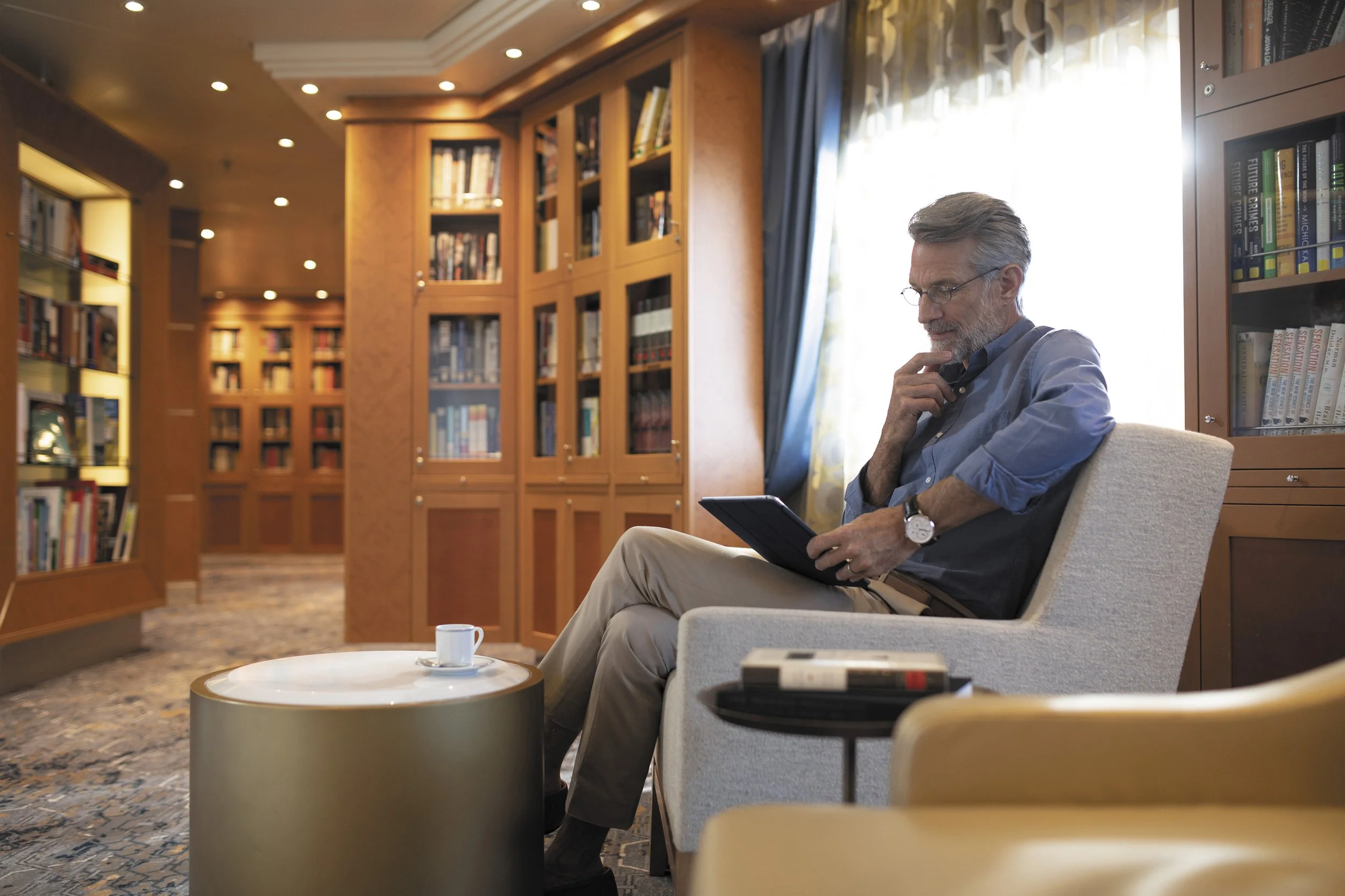Man in a cruise ship library reading.