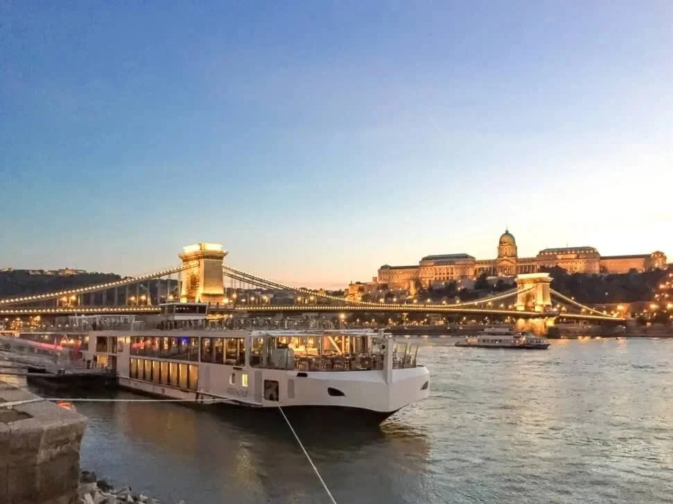 Viking river ship docked near a historic European city center.