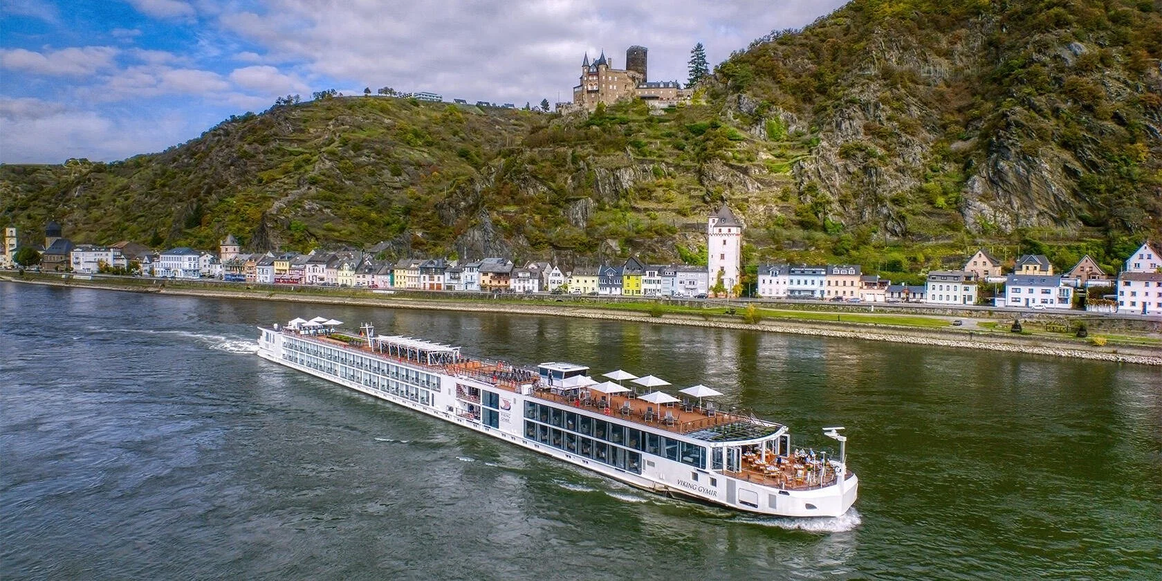 Viking Longship sailing through a scenic European river valley.