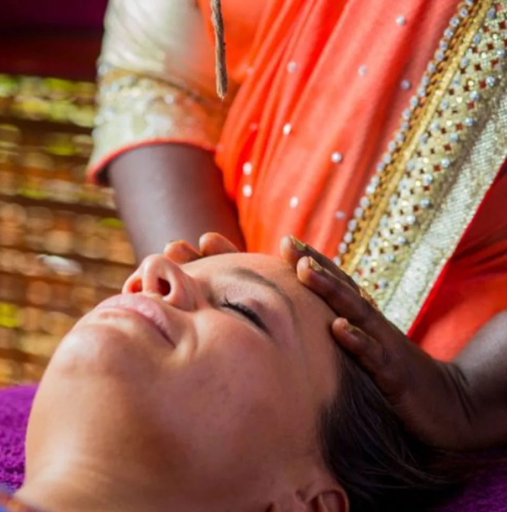 Frau erhält eine Kopfmassage bei einer traditionellen Massagebehandlung.