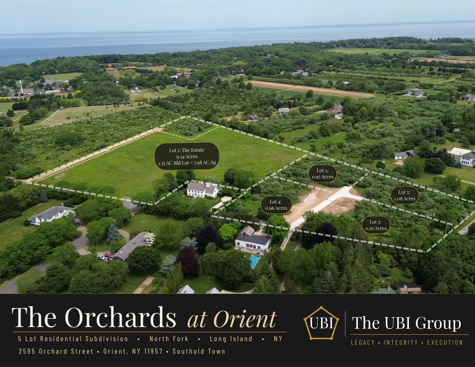 Aerial view of a large land subdivision with outlined lots, including two labeled lots and neighboring houses, set near a body of water, with green trees and fields in the background.