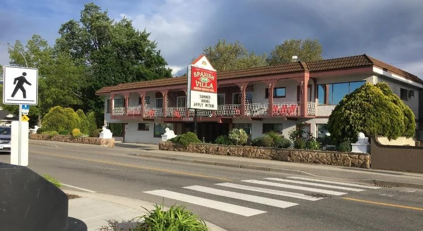 Building with a sign advertising Spanish villa and summer rentals on a street with a pedestrian crossing.