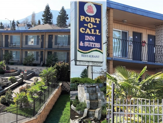 Exterior view of Port-o-Call Inn & Suites hotel with a sign, balconies, landscaped garden, and stairs.
