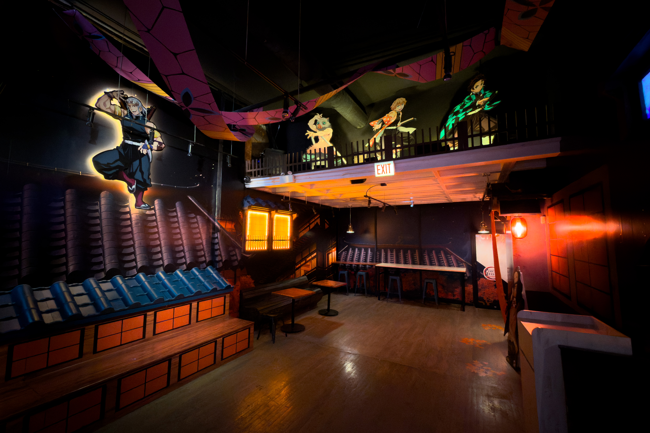 Interior of a Japanese-themed restaurant or bar with wall art of animated samurai characters, dark wood furniture, tiled roof details, and warm lighting.