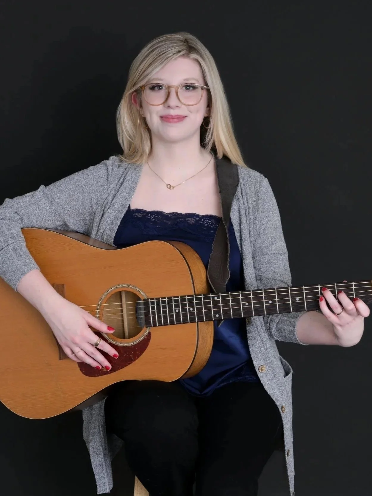 Music Therapist holding a guitar and smiling