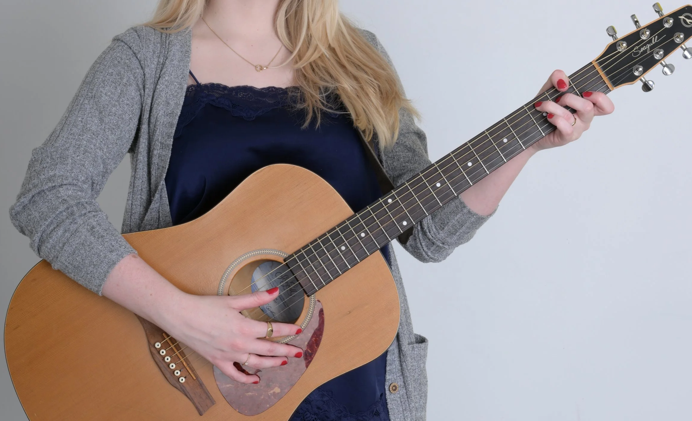 Board-certified music therapist holding an acoustic guitar