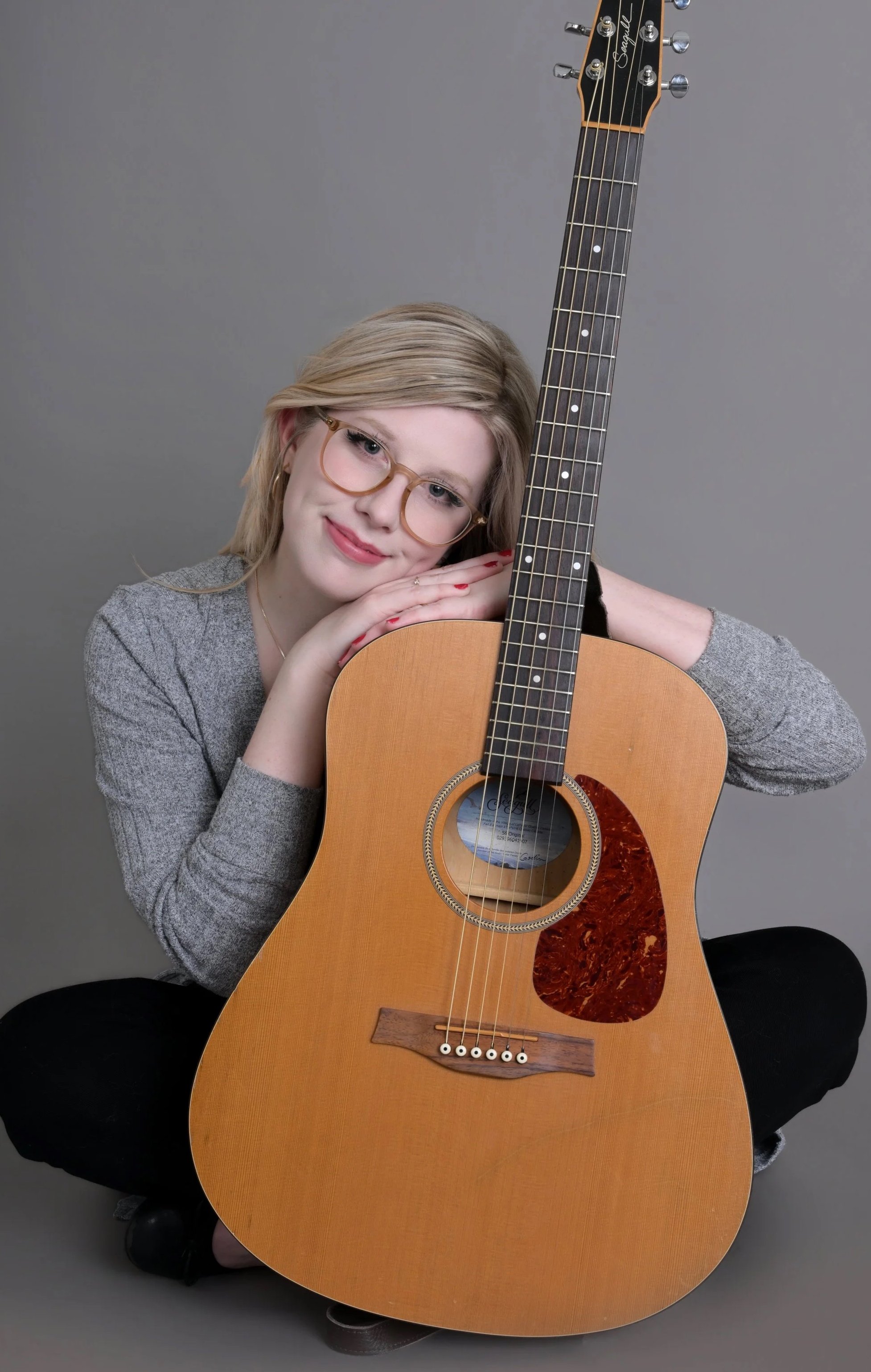 Music Therapist leaning her head against the guitar