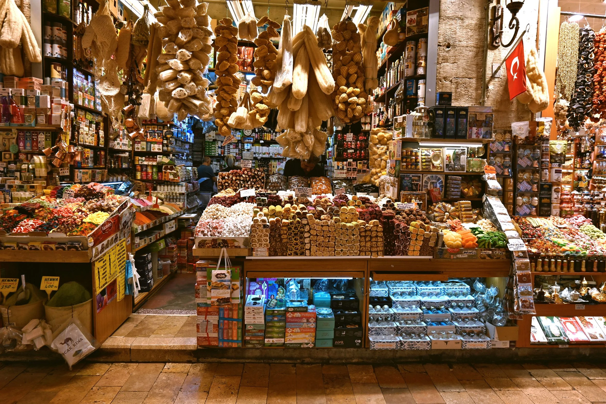 Spice Bazaar stall with shelves of dried goods, sweets and products hanging above the counter, Istanbul.