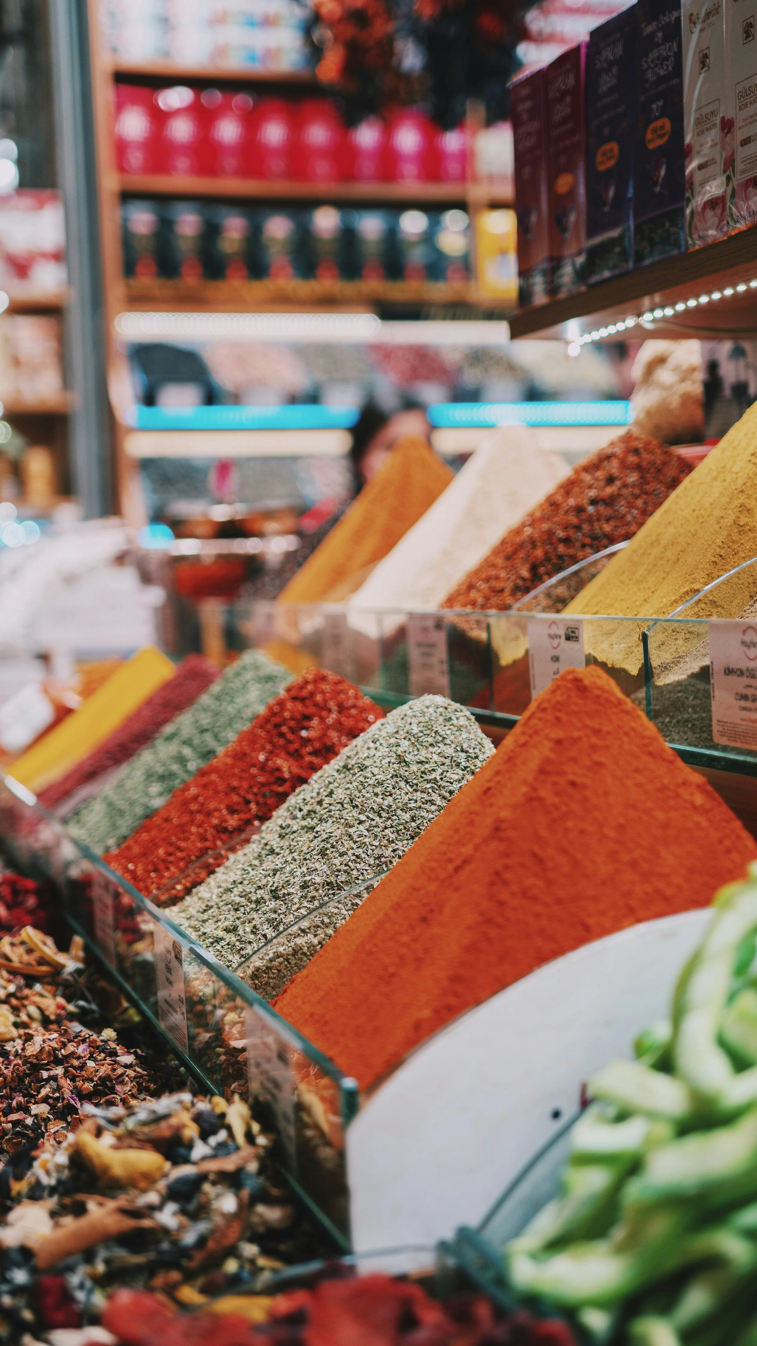 Piles of colorful spices and dried herbs displayed in sloped trays at the Spice Bazaar, Istanbul.