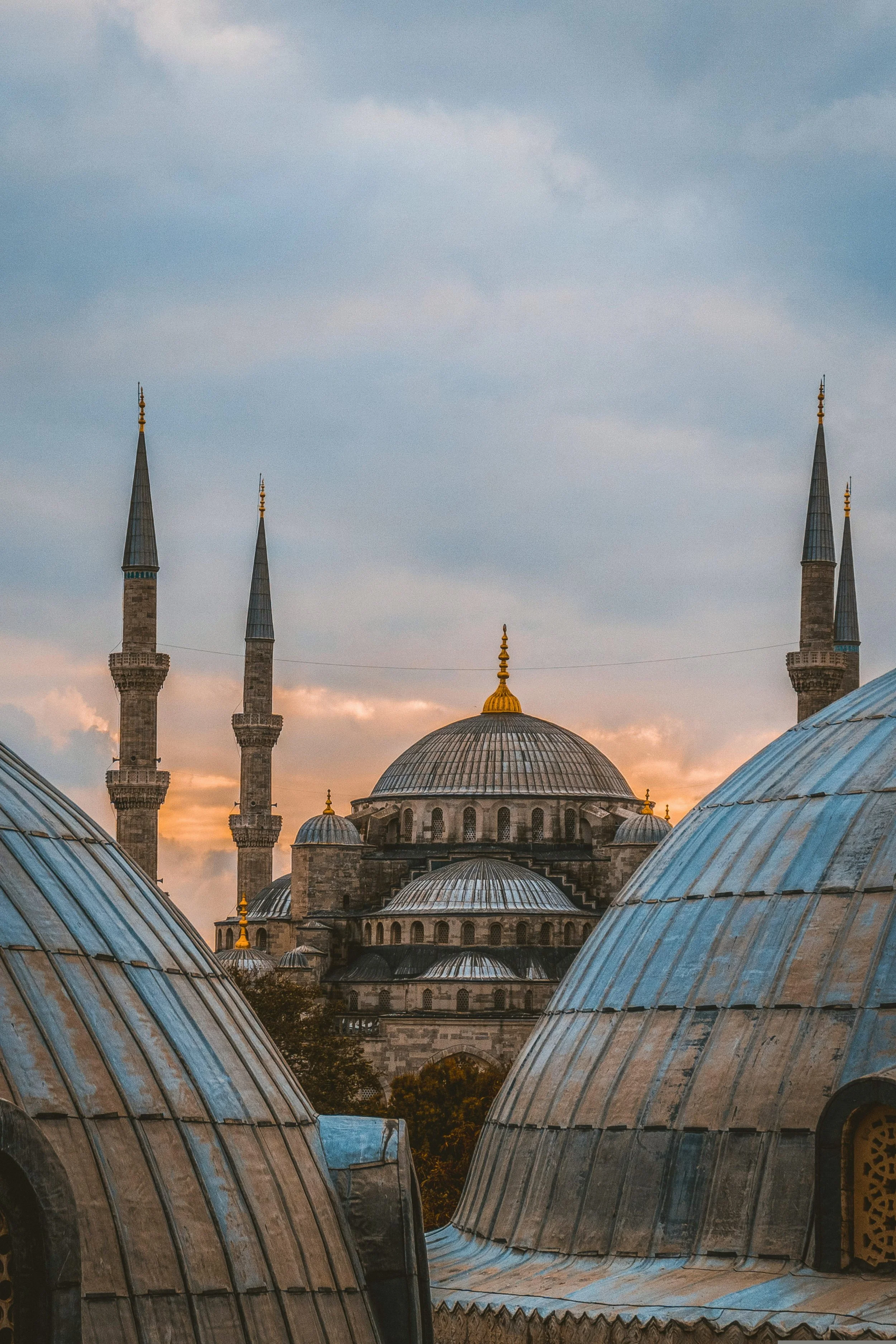 Cascading domes and slender minarets of a mosque seen from above at sunset, Istanbul.
