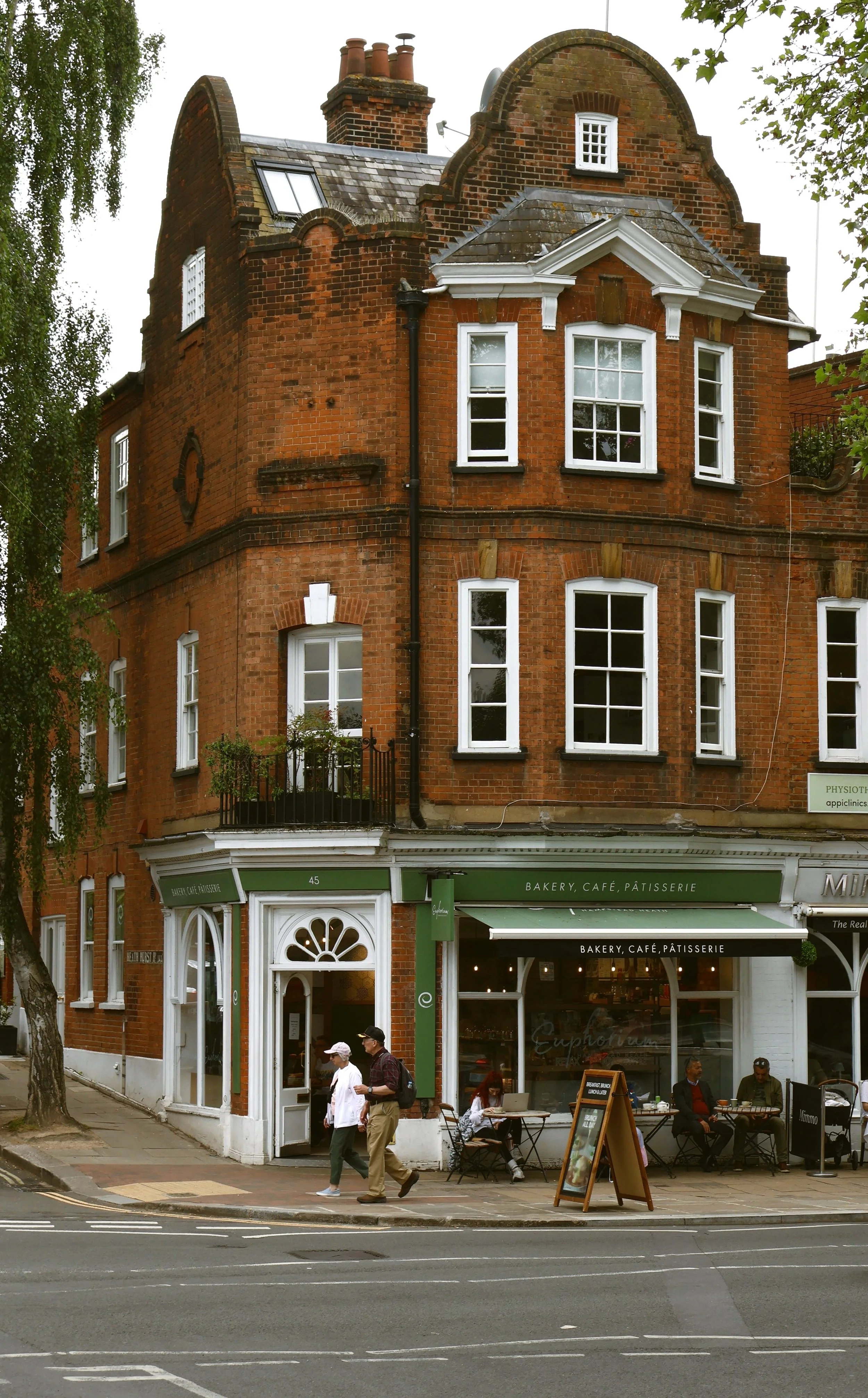 Red-brick corner building with a shopfront at street level, Hampstead, London.