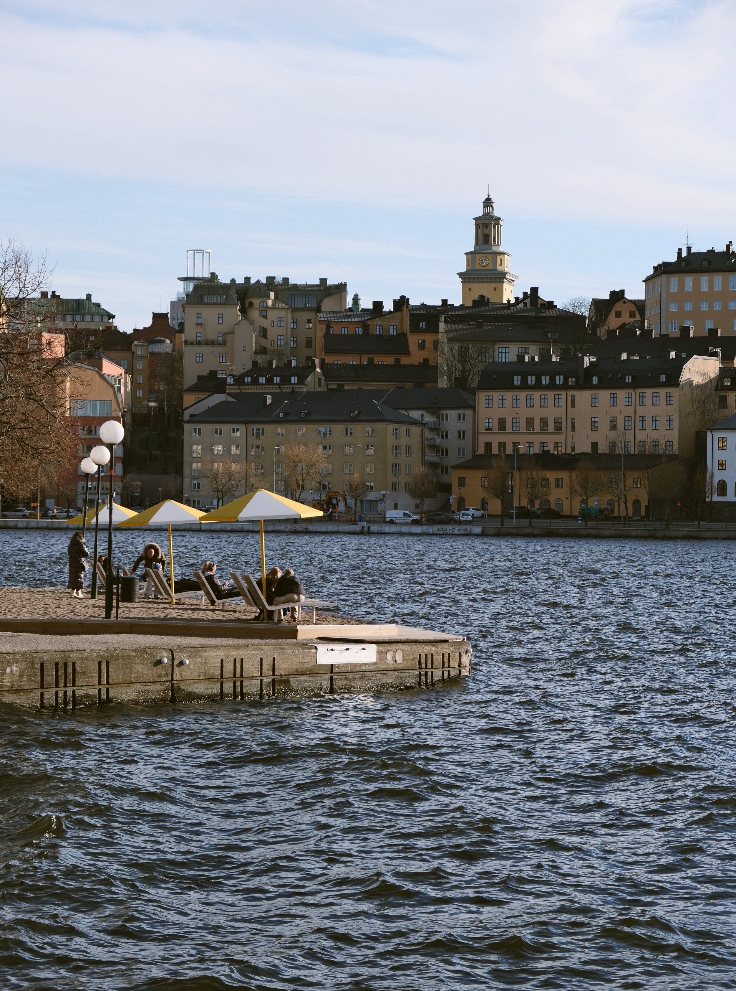 Wooden jetty on the water with Södermalm's skyline across the bay, Stockholm