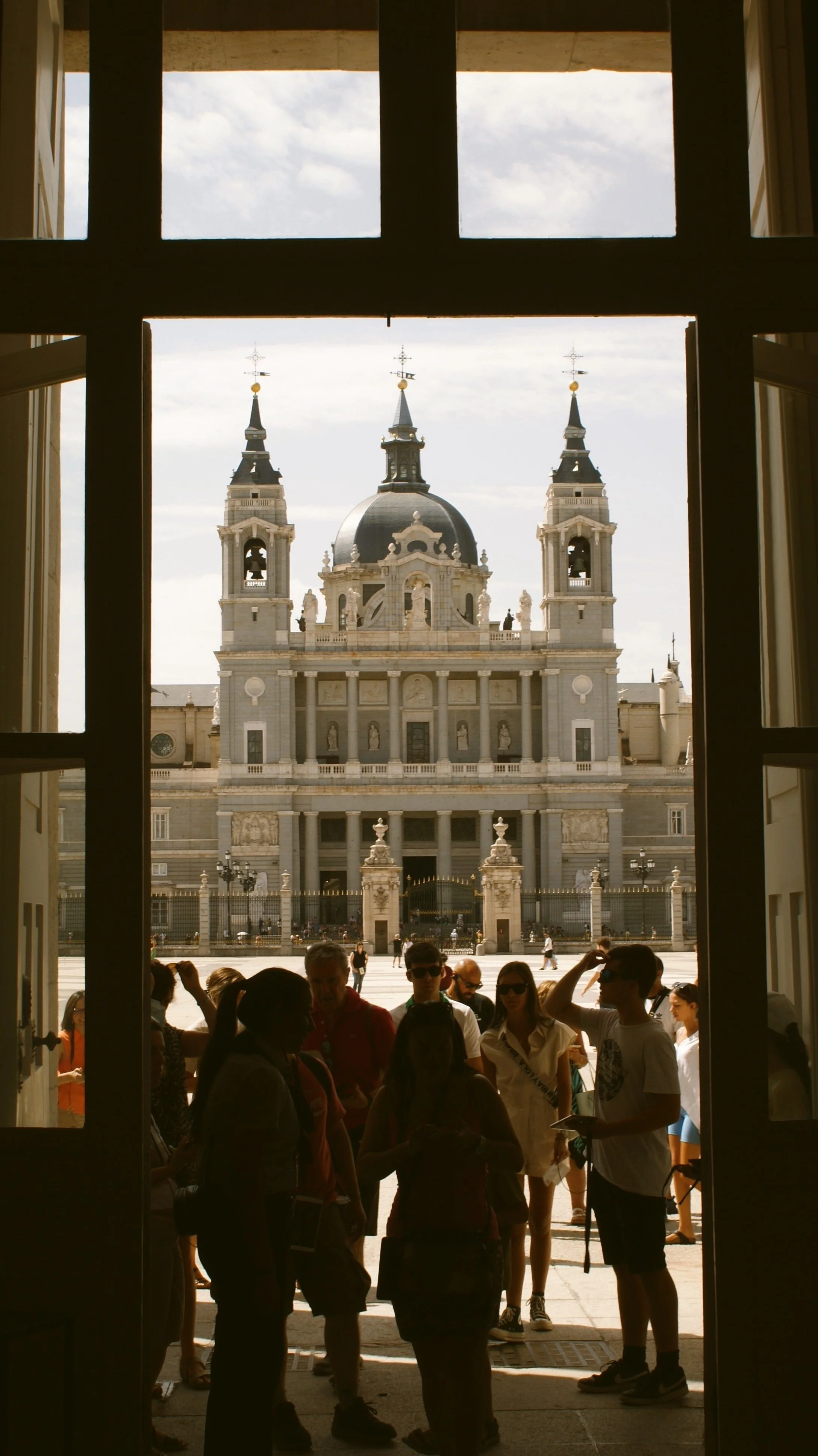 Almudena Cathedral seen through an open window with visitors in the foreground, Madrid