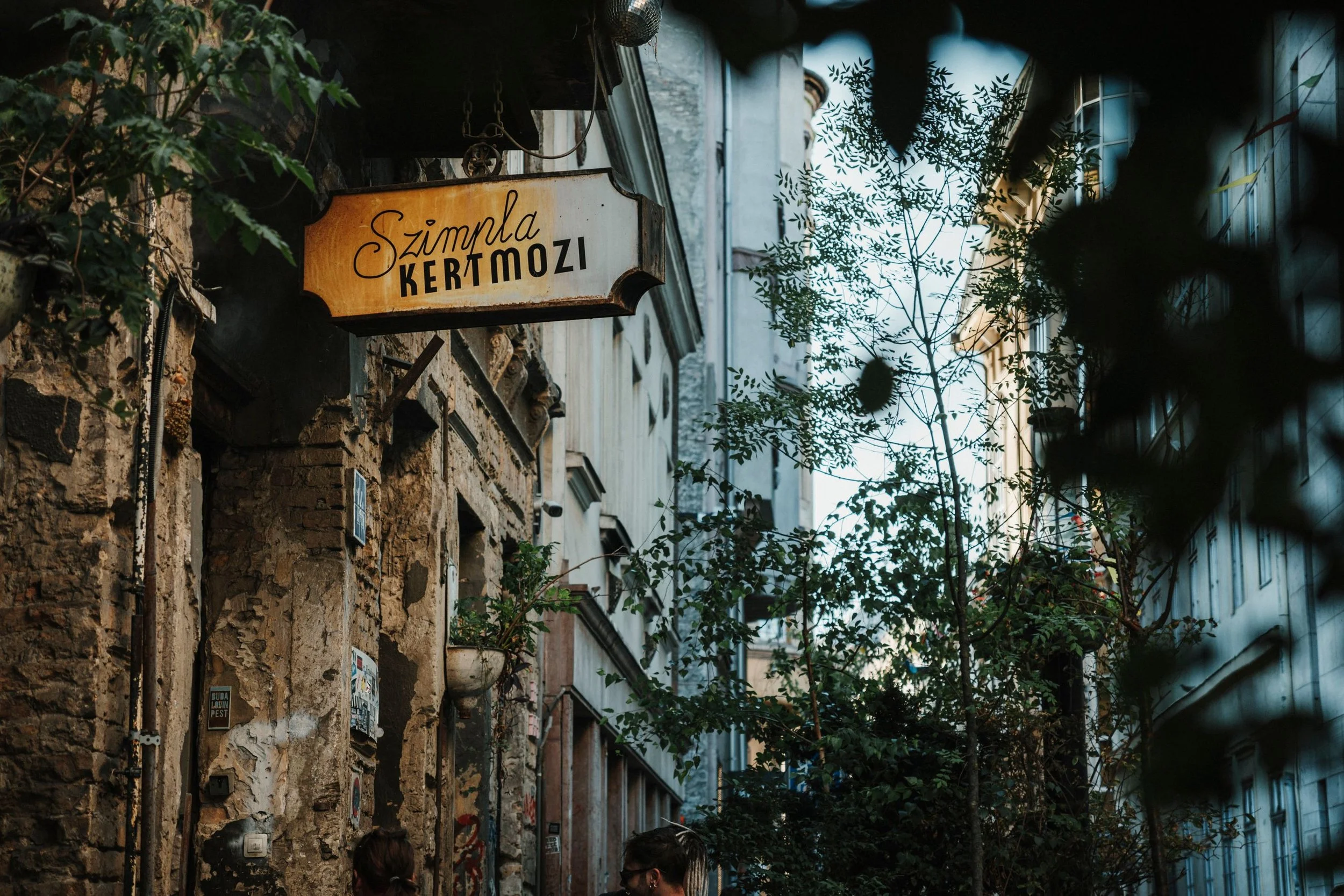 Hanging sign of Szimpla Kert ruin bar, on a weathered building facade in Budapest