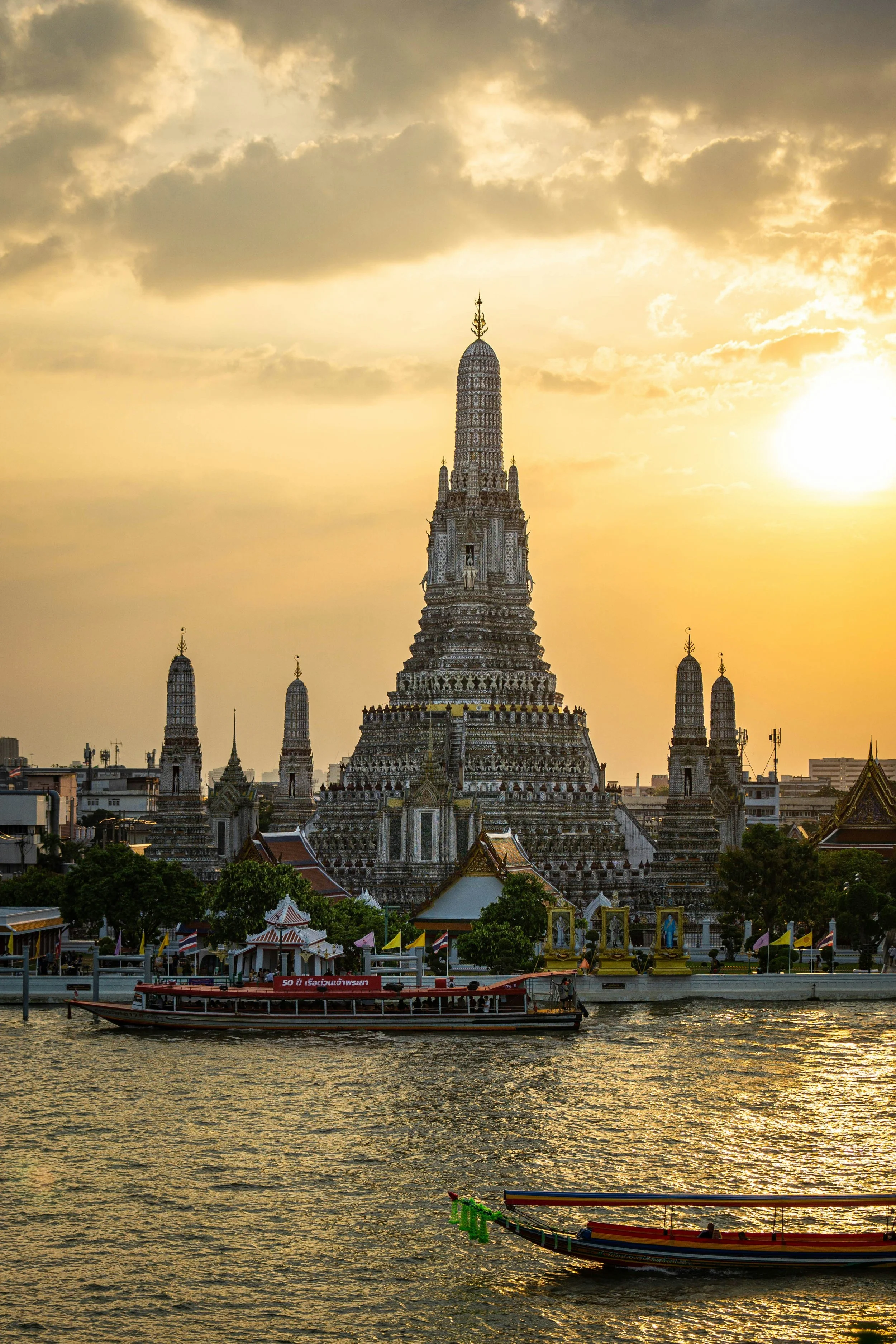 Wat Arun silhouetted at sunset across the Chao Phraya River, Bangkok.