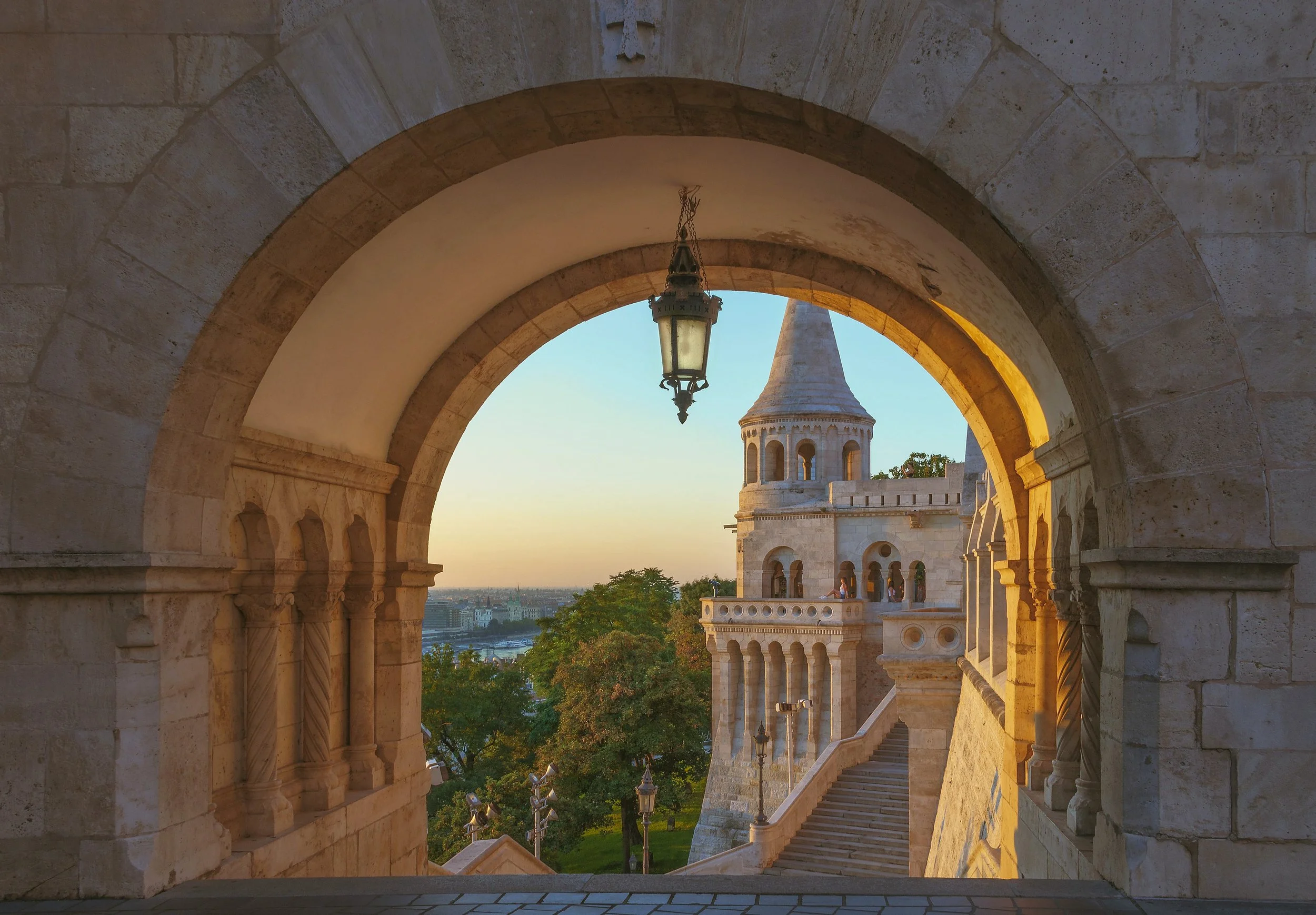 Stone arch framing a turret of Fisherman's Bastion at sunset, Budapest