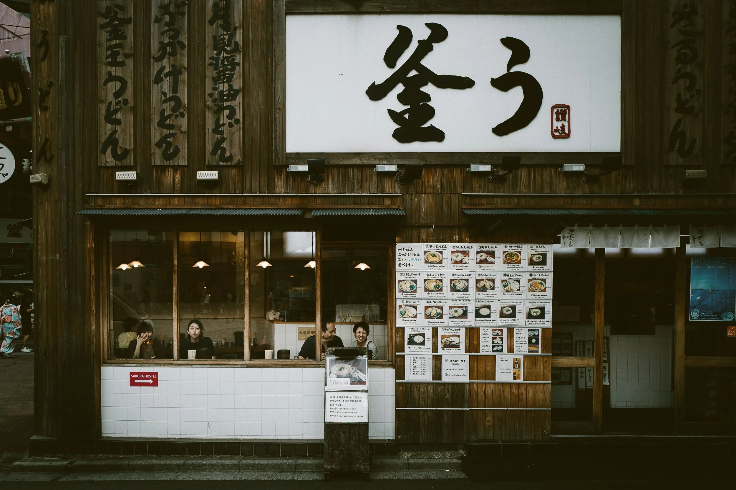 Traditional izakaya wooden facade with a large white sign in Japanese calligraphy, Tokyo.